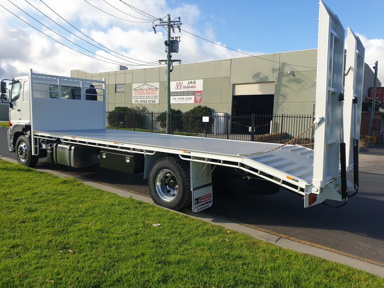 Side view of Hino truck with beavertail tray